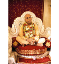 Srila Prabhupada on Cream Colored Vyasanasna with Many Flower Garlands